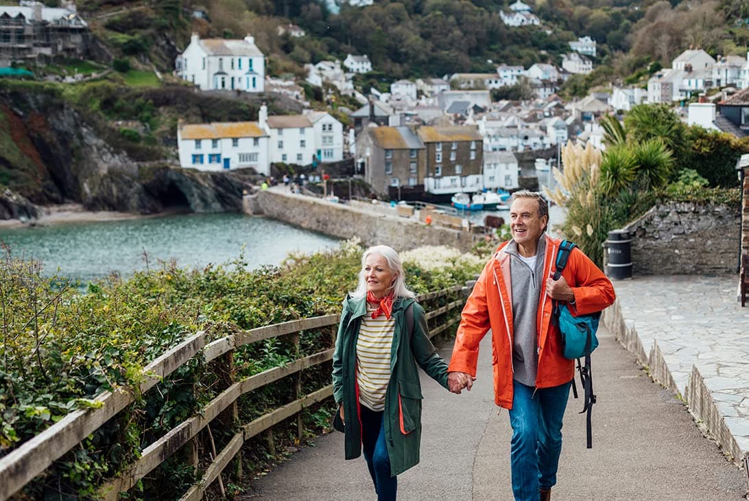 Couple de seniors se promenant dans un village côtier en Europe
